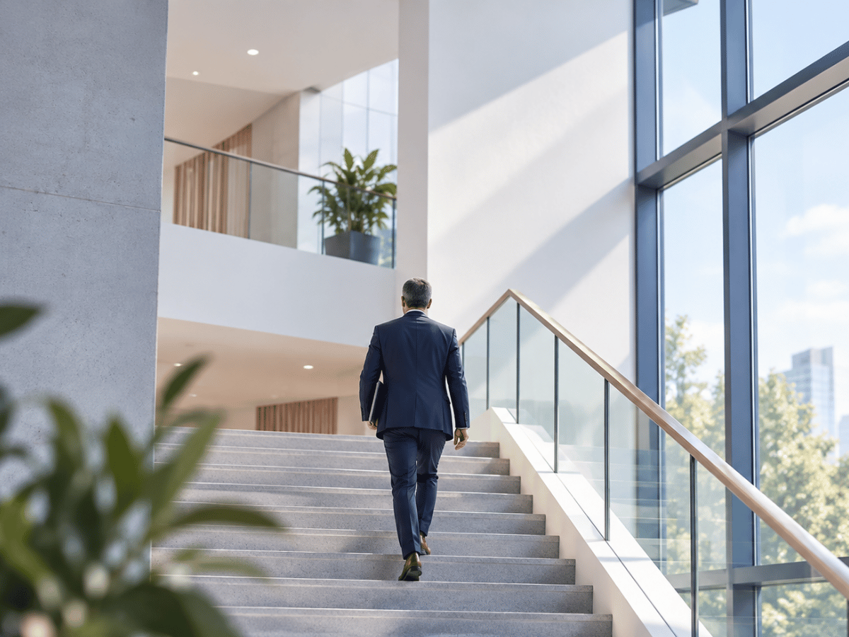 Businessperson walking up stairs in a modern office